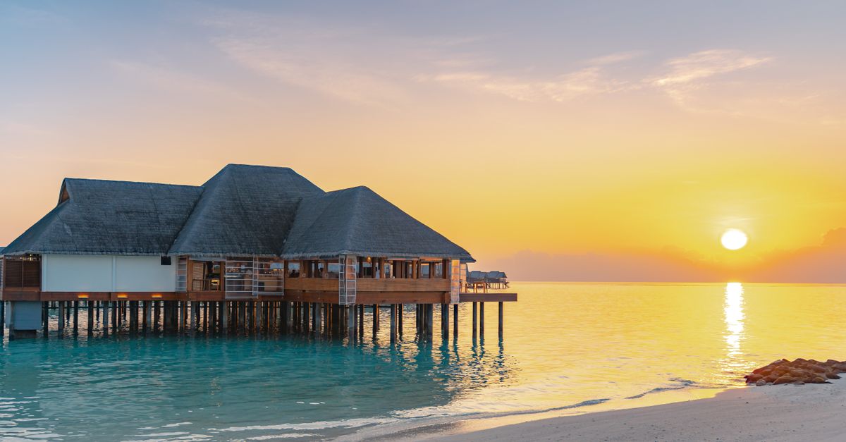 Luxury overwater bungalow with ocean view at sunrise, ideal for tropical travel and vacation.