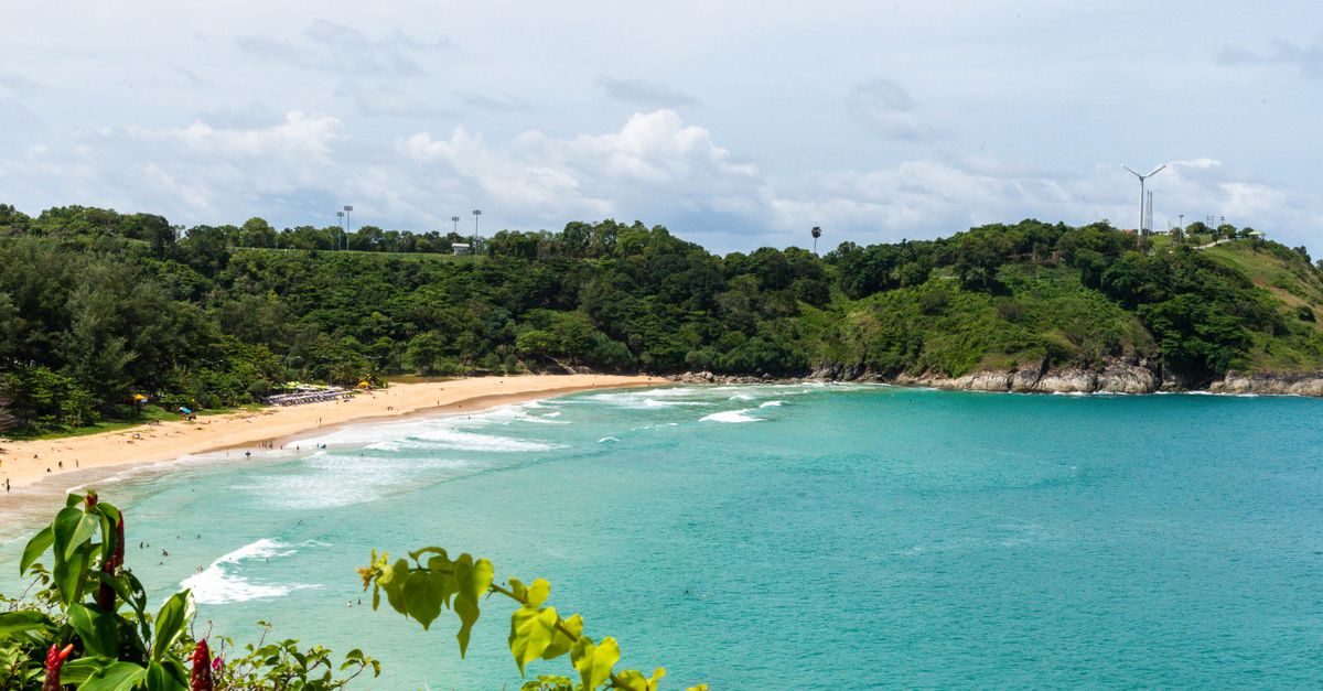Breathtaking view of a tropical beach surrounded by vibrant greenery in Thailand.
