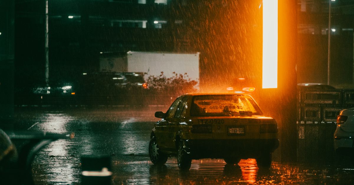 A taxi illuminated by streetlights on a rainy night in Santiago de Querétaro, México.