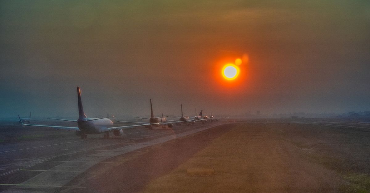 Silhouette of airplanes lined up on the runway at sunset in Banten, Indonesia.