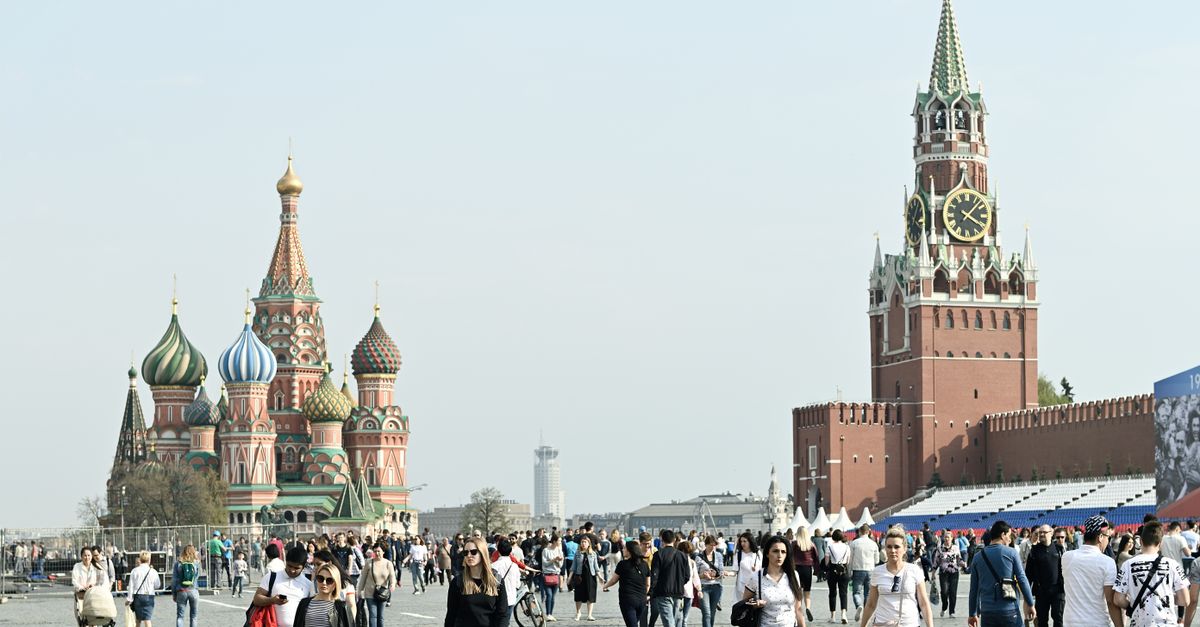 Tourists gather at Moscow's iconic Red Square, featuring St. Basil's Cathedral and Spasskaya Tower.