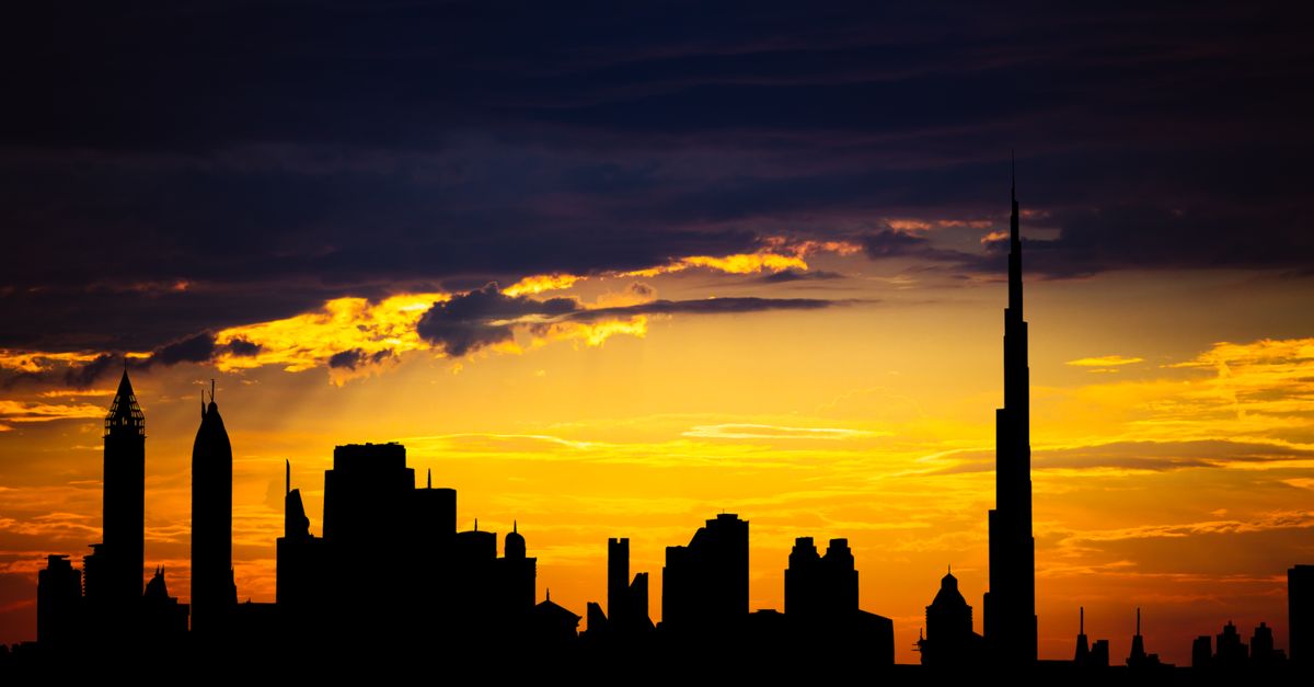 Captivating silhouette of Dubai's skyline with vibrant sunset colors and Burj Khalifa dominating the scene.