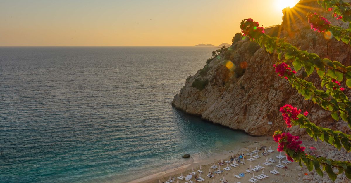 Captivating sunset view of Kaputas Beach in Antalya, featuring vibrant flowers and tranquil waters.