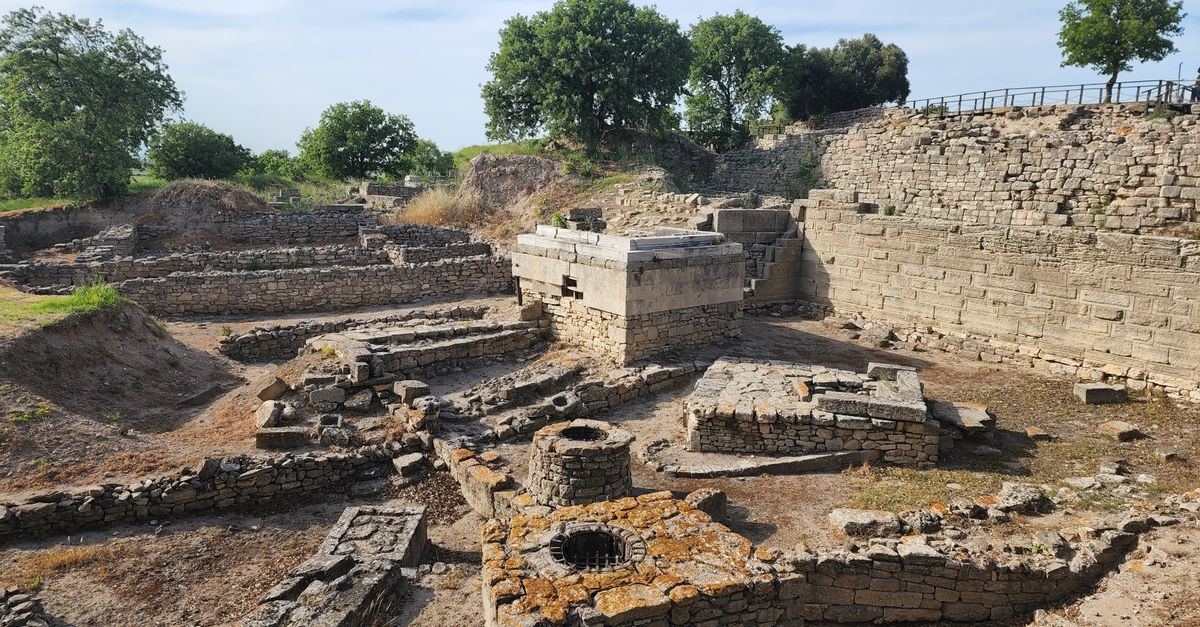 Explore the ancient ruins of Troy in Çanakkale, Turkey, showcasing historical stone structures under a cloudy sky.
